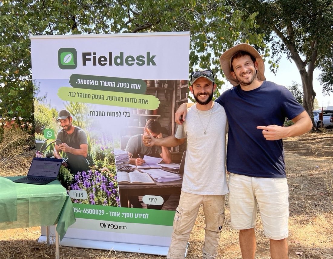 אוהד לוי ושון חודרה בתחרות גוזמי העצים, ליד שלט Fieldesk